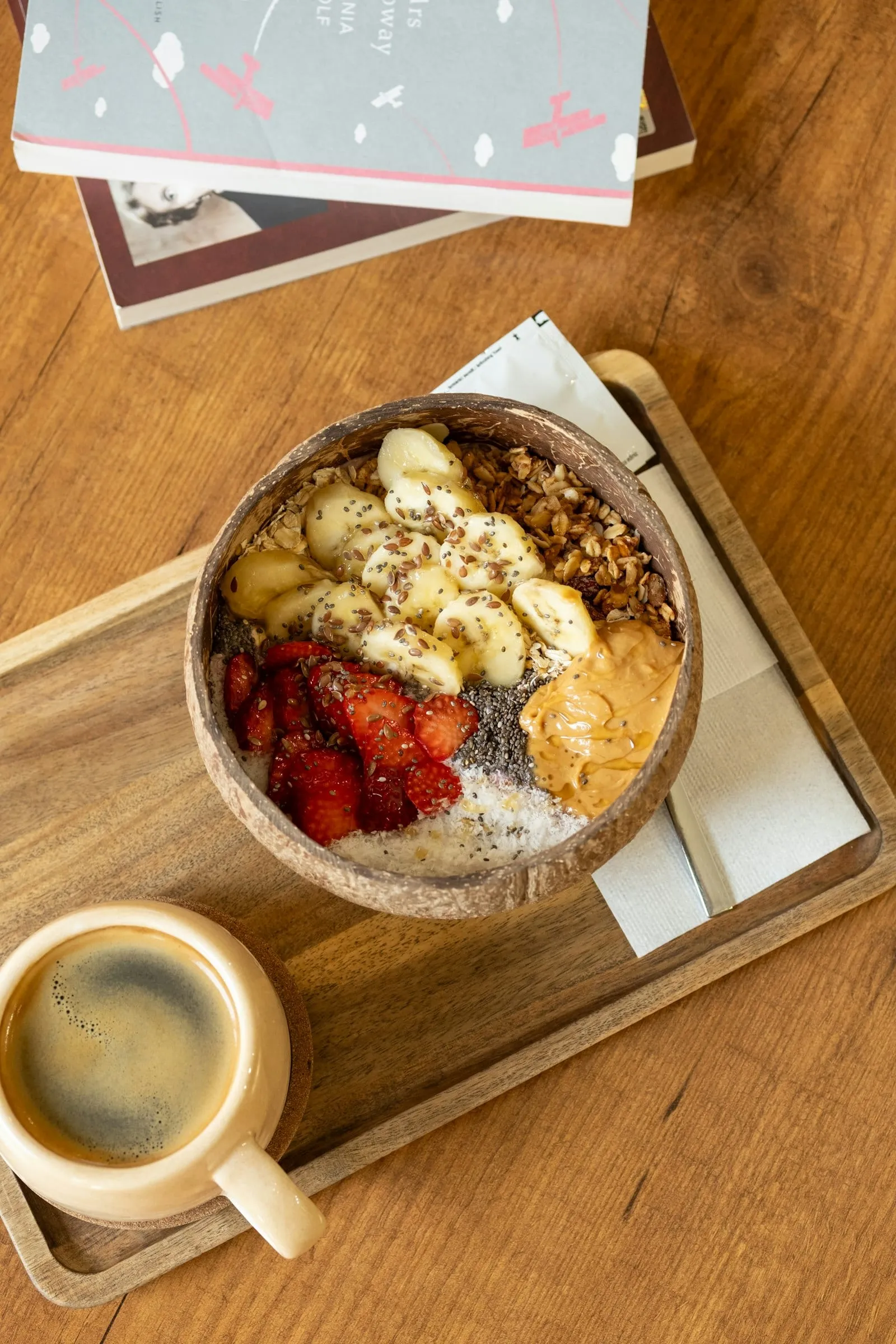 A breakfast bowl with banana, strawberries and peanut butter