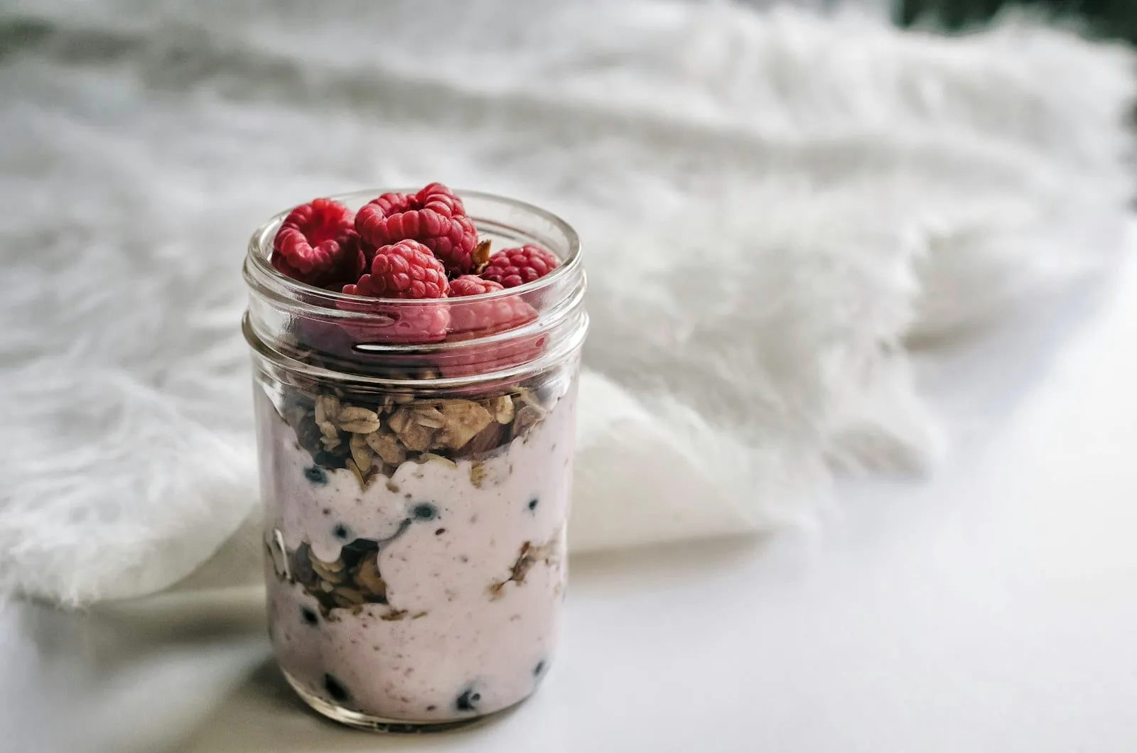A jar of yogurt parfait with berries